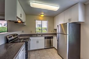 Bonita apartment for rent - A kitchen with a stainless steel refrigerator and white cabinets.