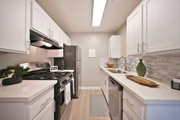 Redlands apartment for rent - A kitchen with white cabinets and a black stove top.