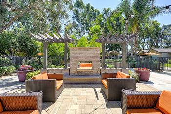 Outdoor lounge area featuring a cozy firepit and fireplace