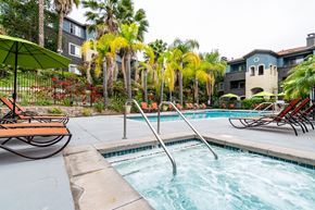 Oceanside apartment for rent - a close photo of a spa with resort-style pool and landscaping in the background