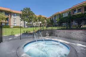 San Diego apartment for rent - A hot tub sits in the middle of a grassy area in front of apartment buildings.