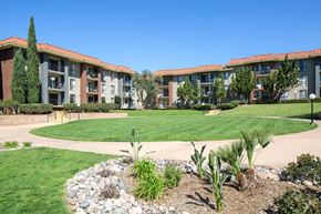 San Diego apartment for rent - A building with a red tile roof and a green lawn in front.
