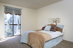 San Diego apartment for rent - A bedroom with a large bed and a window with curtains.