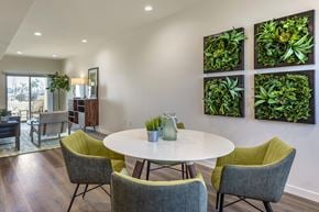 Anaheim apartment for rent - A dining room with a white table and green chairs.