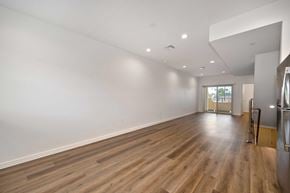 Anaheim apartment for rent - Spacious living room with vinyl wooden flooring and white walls.