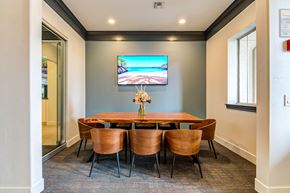 Oceanside apartment for rent - a business conference room with a table and chairs and a tv on the wall