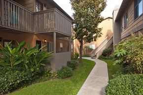 Carlsbad apartment for rent - a sidewalk in front of an apartment building with grass and plants