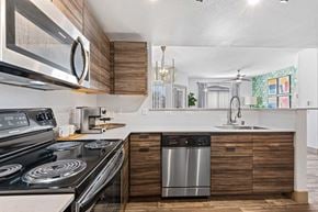 Las Vegas apartment for rent - A modern kitchen with a stainless steel stove and a wooden cabinet.