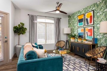 Las Vegas apartment for rent - A living room with a blue couch and a green plant.