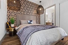 Las Vegas apartment for rent - A bedroom with a large bed and a patterned wallpaper.
