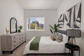 Fort Collins apartment for rent - A bedroom with a bed, dresser, and a large window.