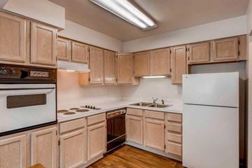 Greeley apartment for rent - A kitchen with wooden cabinets and a white refrigerator.