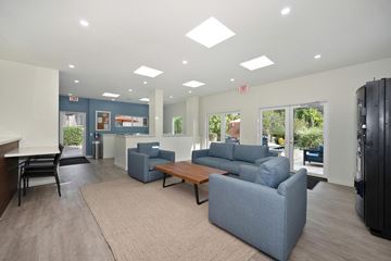 Oceanside apartment for rent - A spacious living room with a grey sofa set and a wooden coffee table.