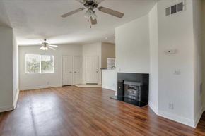 Las Vegas apartment for rent - A living room with a fireplace and a ceiling fan.