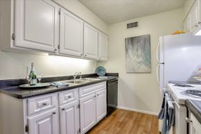 Las Vegas apartment for rent - A kitchen with white cabinets and a black countertop.