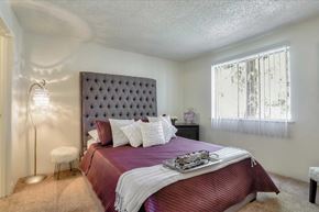 Las Vegas apartment for rent - A bedroom with a large bed and a window with curtains.