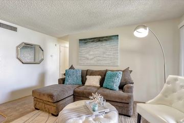 Las Vegas apartment for rent - A living room with a brown couch and a white chair.
