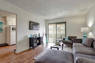 Las Vegas apartment for rent - A living room with a grey couch and a wooden floor.