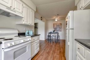 Las Vegas apartment for rent - A kitchen with a stove, refrigerator, and a dining table with chairs.