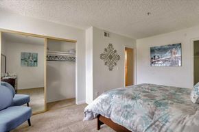 Las Vegas apartment for rent - A bedroom with a bed, a couch, and a painting on the wall.