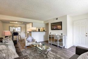 Las Vegas apartment for rent - A living room with a couch, a chair, a coffee table, and a painting on the wall.