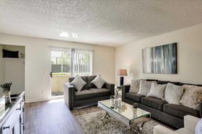 Las Vegas apartment for rent - A living room with a grey couch and a glass coffee table.