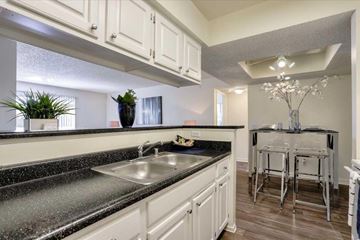 Las Vegas apartment for rent - A kitchen with a black granite countertop and white cabinets.