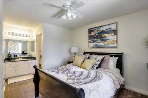 Las Vegas apartment for rent - A bedroom with a bed, a ceiling fan, and a painting on the wall.