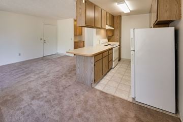 Lakeside apartment for rent - A kitchen with a white refrigerator and wooden cabinets.
