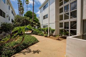 Sherman Oaks apartment for rent - Exterior of Summerview with concrete pathway that leads through a landscaped courtyard between two of the community buildings.