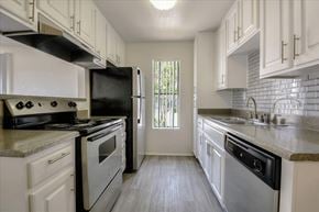 Escondido apartment for rent - A kitchen with black appliances and white cabinets.