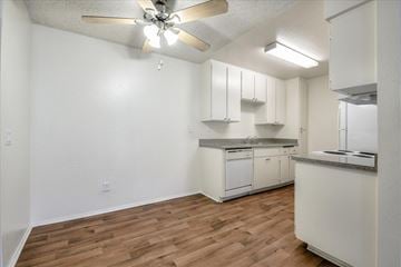 Escondido apartment for rent - A kitchen with white cabinets and a ceiling fan.