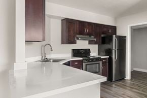 La Jolla apartment for rent - A kitchen with a white counter top and dark brown cabinets.