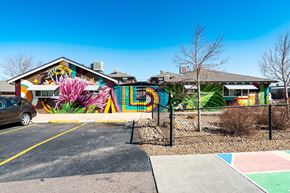 Lakewood apartment for rent - A mural of a pink flower is on the side of an apartment building.