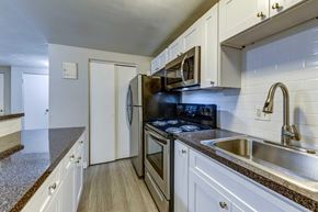 Lakewood apartment for rent - A kitchen with a black stove top oven and white cabinets.