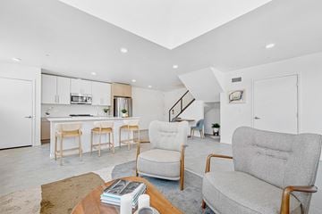 San Diego apartment for rent - A living room with a grey couch and a coffee table with a book on it.