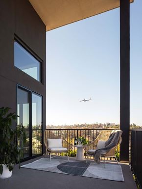 San Diego apartment for rent - Balcony view with plane of two-story balcony and low seating with table.