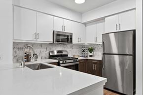 Los Angeles apartment for rent - The Elinor's two bedroom modern kitchen with a stainless steel appliances, white and ebony colored cabinets, and quartz white countertops.