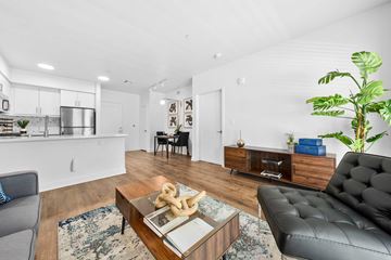 Los Angeles apartment for rent - A modern living room with a black leather sofa and a wooden coffee table.