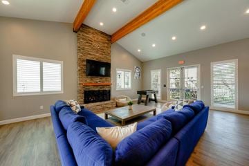 Fresno apartment for rent - A blue couch in a living room with a fireplace and a flat screen TV.