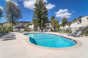 Fresno apartment for rent - A swimming pool surrounded by lounge chairs.