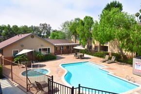 Oceanside apartment for rent - The community swimming pool with spa and lawn chairs surrounding the pool.