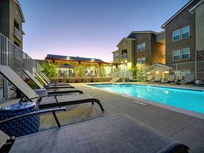 Santee apartment for rent - A swimming pool surrounded by lounge chairs and apartment buildings.