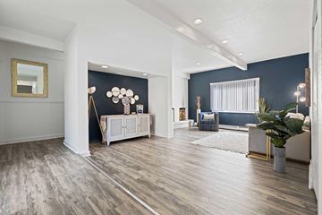 Greeley apartment for rent - A living room with a grey sofa and a white side table.