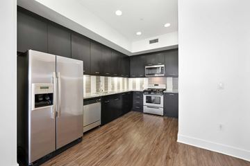 Anaheim apartment for rent - A modern kitchen with a stainless steel refrigerator and wooden floors.