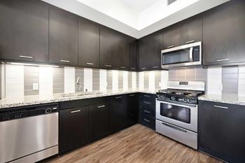 Cook in style with fully equipped kitchen with stainless steel appliances, including a refrigerator, stove, microwave, dishwasher, and garbage disposal