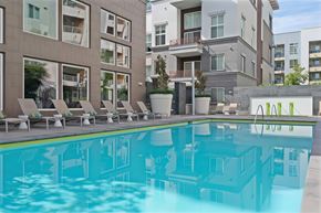 Anaheim apartment for rent - The large community swimming pool with lounge chairs surronding.