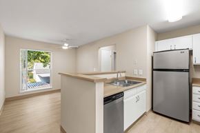 Beaverton apartment for rent - Kitchen with wood-style vinyl plank flooring and view to living room.