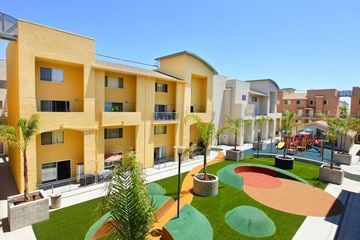 San Diego townhouse for rent - A playground area with a slide and a green lawn in front of apartment buildings.
