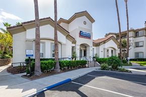 Oceanside apartment for rent - a large white leasing office building with a blue sign on the front of it